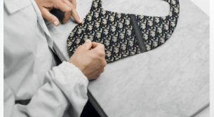 Artisan inspecting a navy oblique-pattern saddle bag on a marble workbench